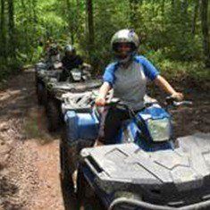 Close up of an ATV rider on a forest trail.